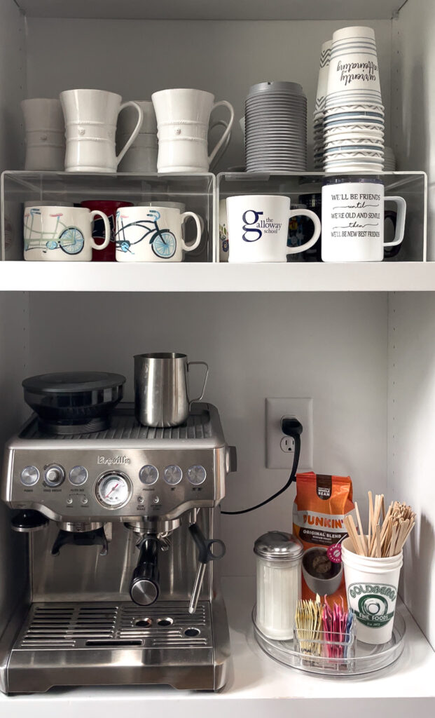 Acrylic shelf risers utilizing vertical space to organize coffee mugs at an at-home coffee station.