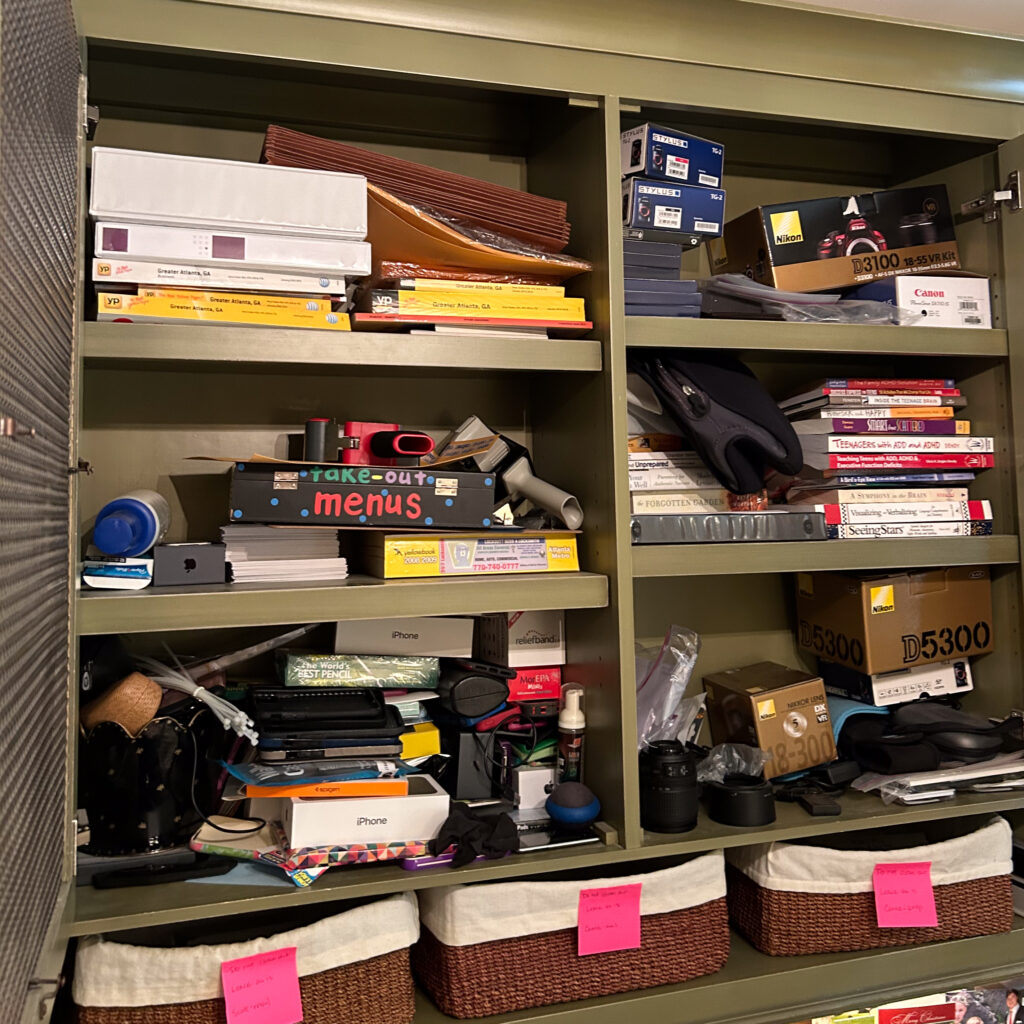 A cluttered cabinet in an office.