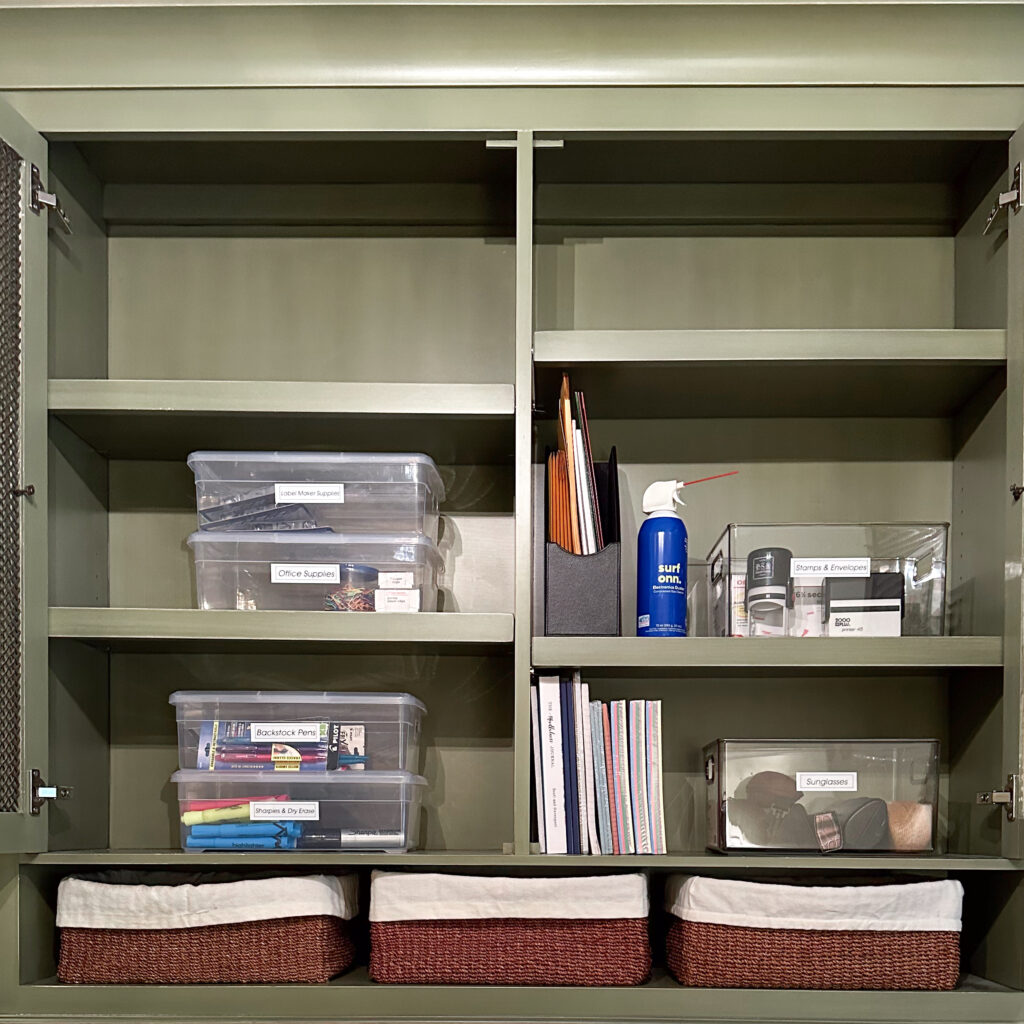 An office cabinet organized with clear acrylic bins, labels, and baskets.