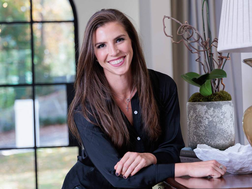 Photo of UpTown Concierge founder, Kat Duncan in a black button-down shirt in a lovely home. 