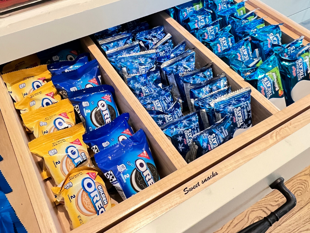 Snack drawer perfectly organized with Oreos and Rice Krispie Treats ready for kids to grab with easy to read labels. New Blog post Why Your Home Gets Messier in the Summer 